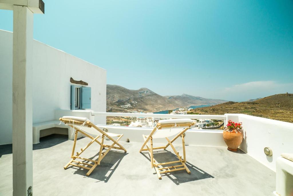 uma varanda com cadeiras e vista para o oceano em Plori Studios and Apartments em Aegiali