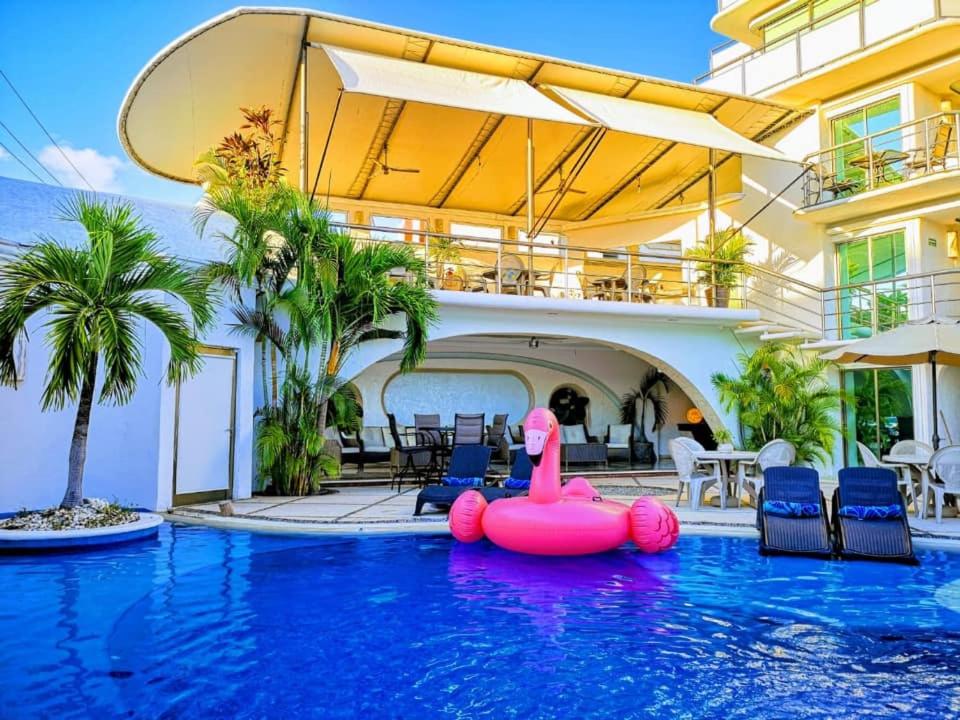 an inflatable flamingo in the swimming pool of a hotel at Hotel Blue Star Cancun in Cancún