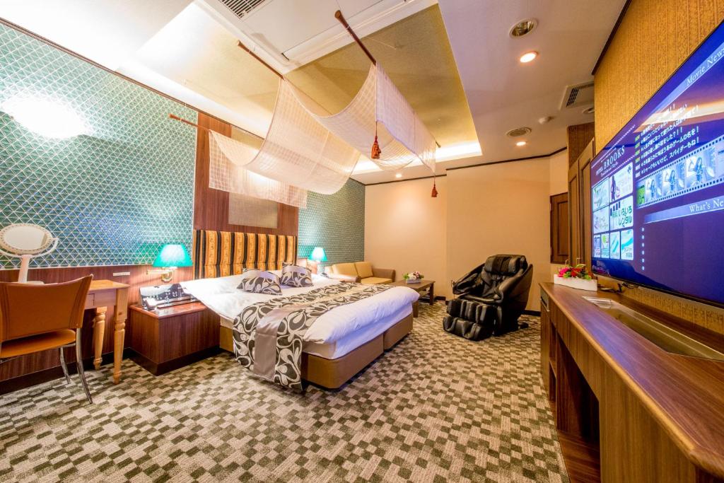a hotel room with a bed and a flat screen tv at Hotel Brooks (Adult Only ) in Kasukabe