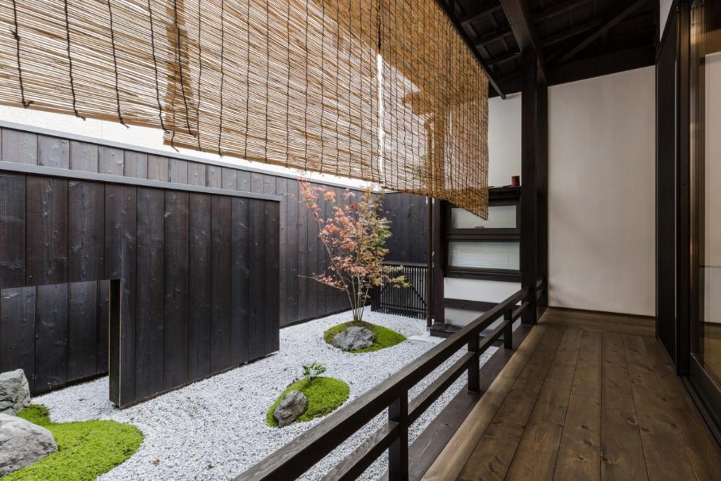 un giardino nel mezzo di una stanza con recinzione di 京町家一棟貸しKyoto Machiya Stay En a Kyoto