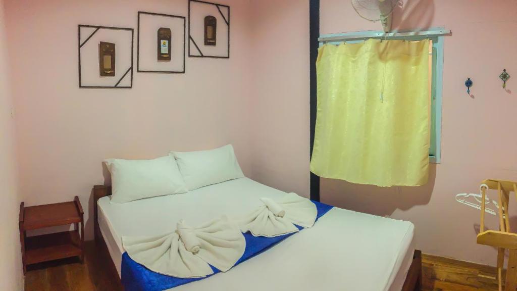 a small bed in a room with a yellow curtain at Sangchan hostel in Ko Lipe