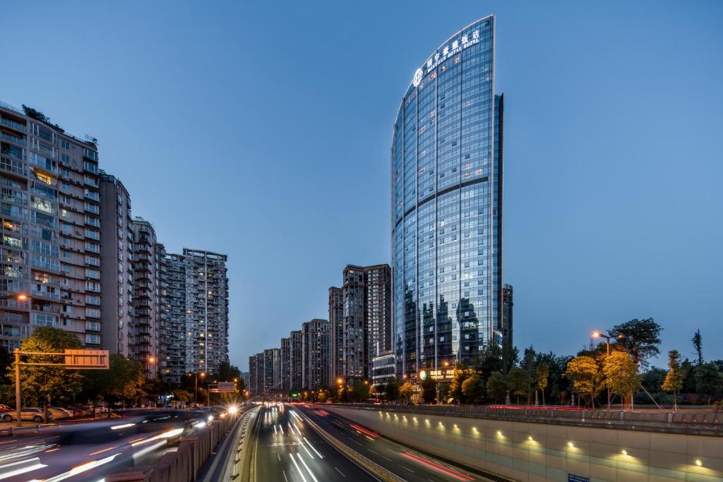 Minyoun Chengdu Kehua Hotel – Member of Preferred Hotels & Resorts في تشنغدو: مدينة ذات مباني طويلة وشارع به سيارات