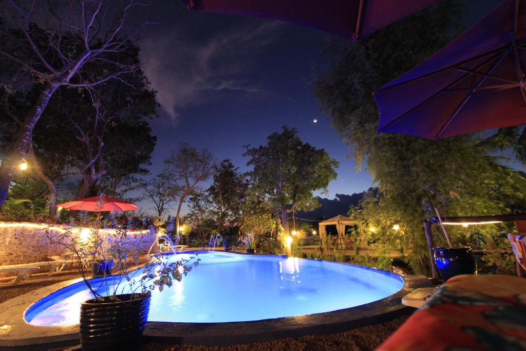 una gran piscina por la noche con sombrilla en Discovery Island Resort, en Corón