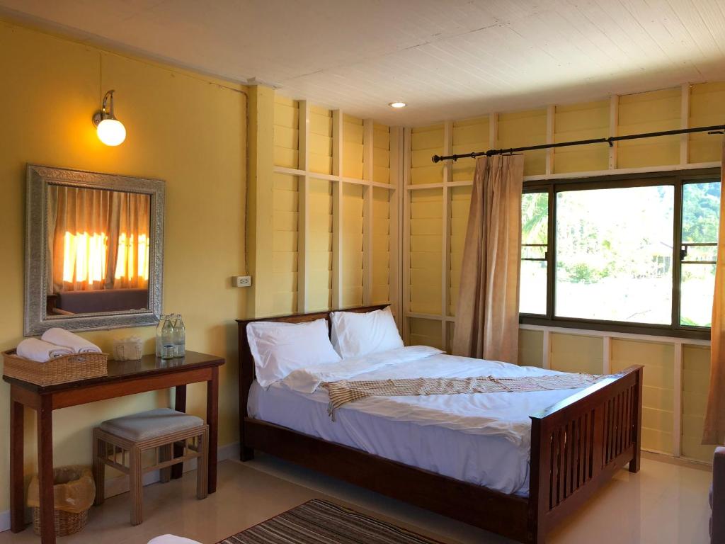 ein Schlafzimmer mit einem Bett und einem Tisch und einem Fenster in der Unterkunft Green Hill Resort Phurue in Phu Rua