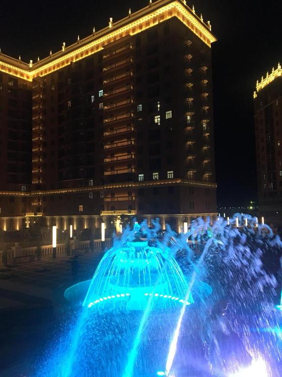a fountain with blue lights in front of a building at TRILLIONER Apartment 885 in Aktau