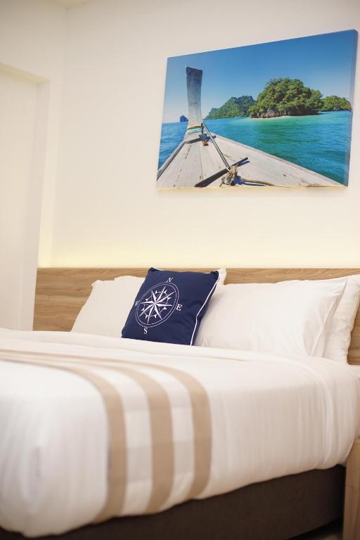 a bedroom with a bed with a picture on the wall at Aquavana Haad Rin Resort in Haad Rin