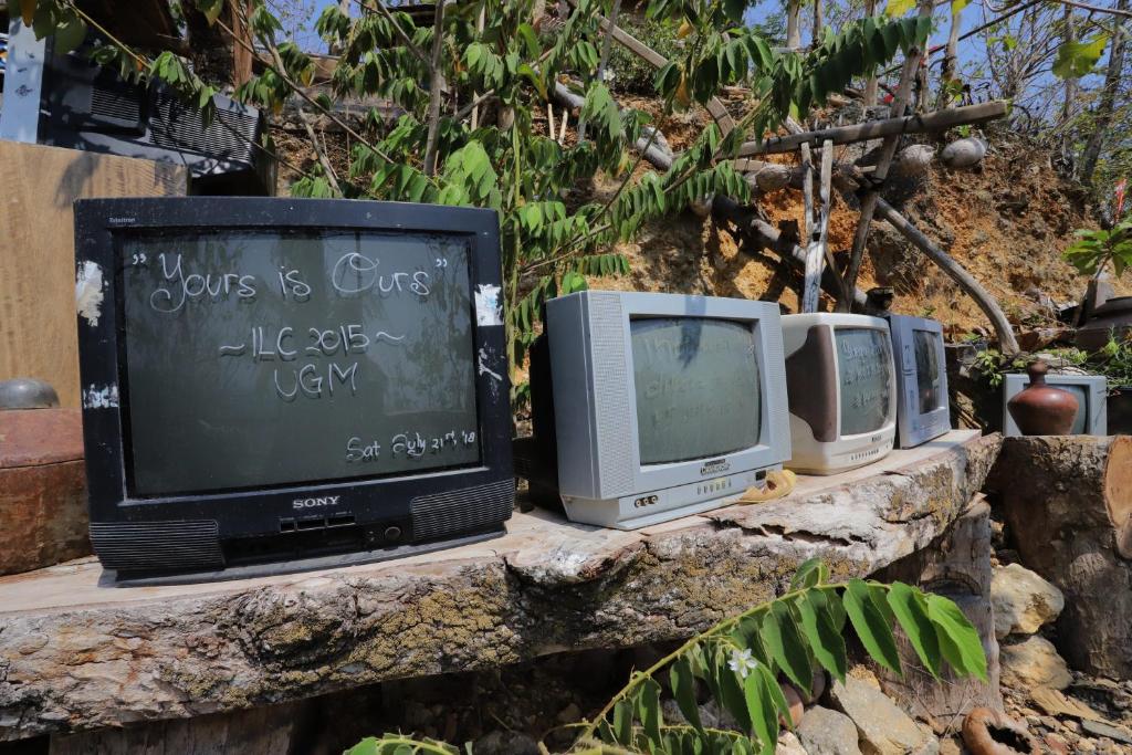 una fila de viejos televisores sentados en una pared de piedra en NewAlasKuliner & HomestayWatulumbung, en Yogyakarta
