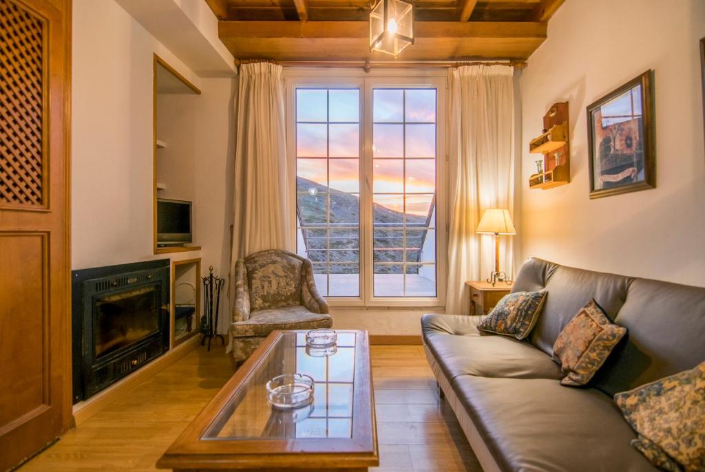 salon z kanapą i kominkiem w obiekcie Exclusivo DÚPLEX en la PLAZA w mieście Sierra Nevada