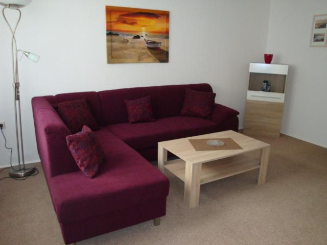 a living room with a purple couch and a coffee table at Ferienwohnung S und K Bremerhaven in Bremerhaven