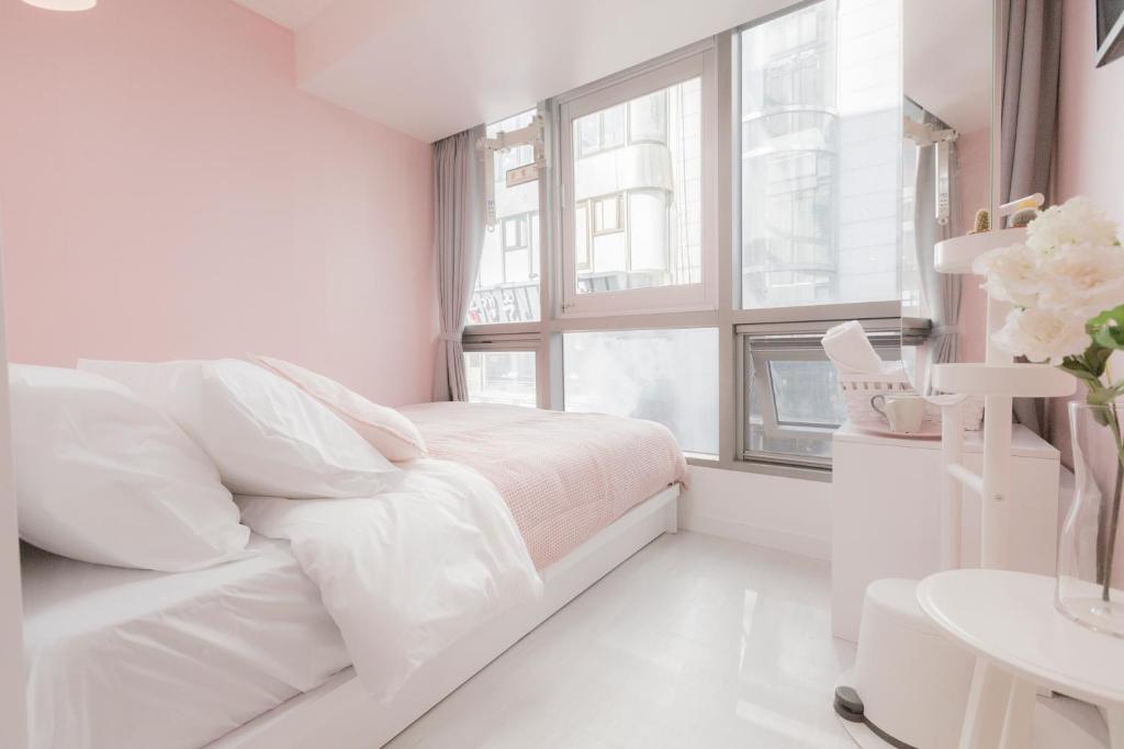 a white bedroom with a bed and a window at MJ Stay 2 in Seoul