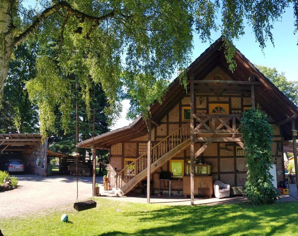 a log cabin with a staircase in the yard at Gemütliche Ferienwohnung in Schneverdingen