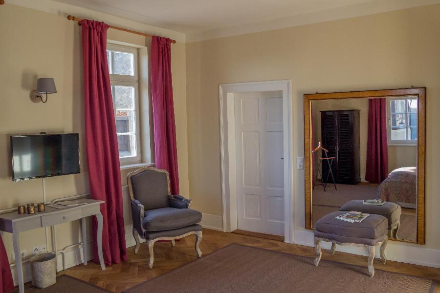 a living room with a mirror and red curtains at Apartment Schloßblick in Langenburg