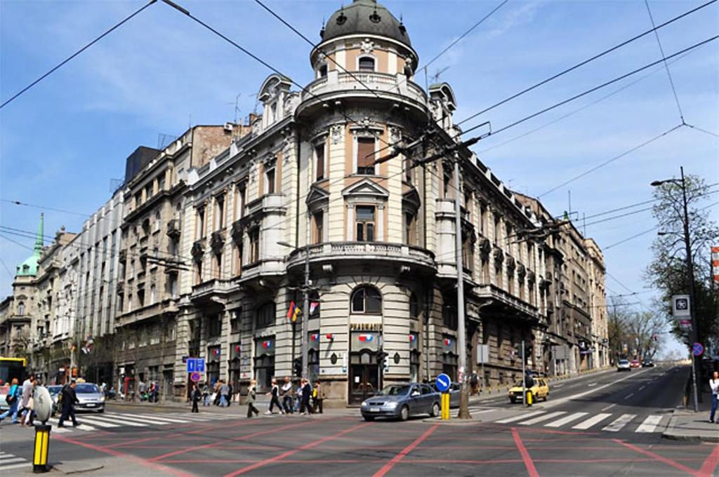 um edifício numa rua da cidade com um carro na frente em Habitat Hostel em Belgrado