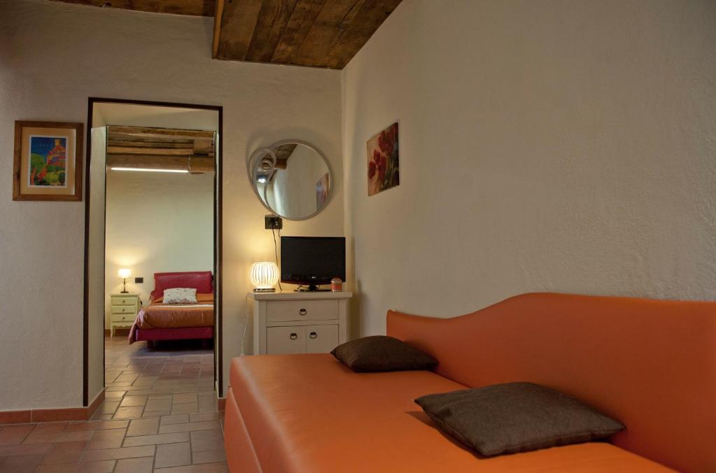 アルチドッソにあるThalassa Locanda B&B e appartamentoのベッドルーム(オレンジ色のベッド1台、鏡付)