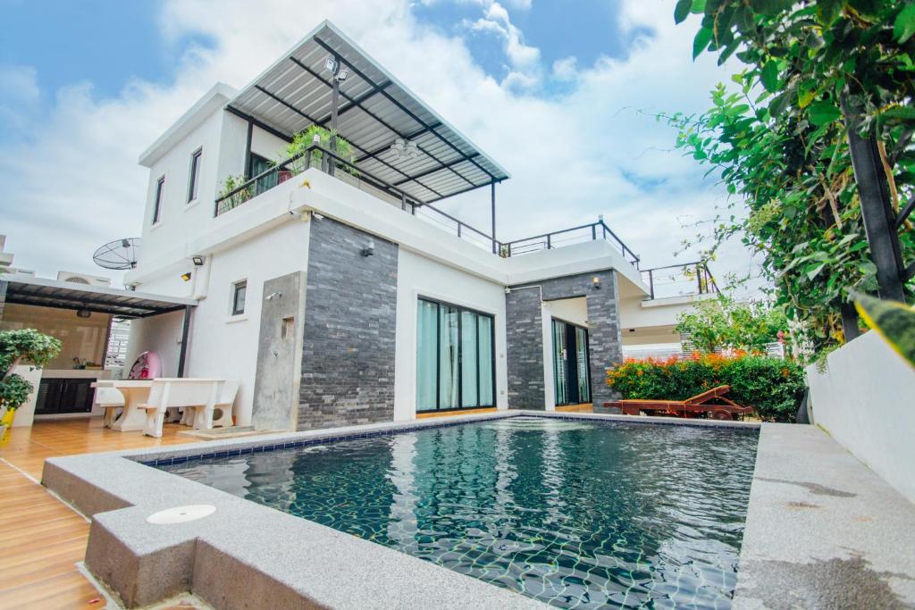 una casa con piscina frente a ella en FullLove HuaHin PoolVilla en Hua Hin