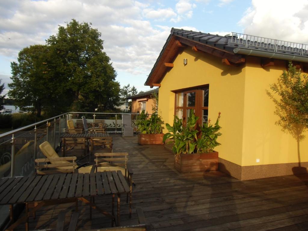 eine Terrasse mit Stühlen und Tischen sowie ein Gebäude in der Unterkunft Ferien am See in Schwerin