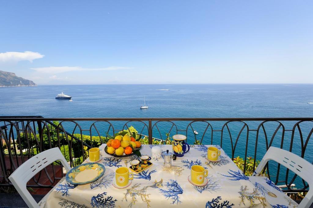 a table with a plate of fruit on a balcony at LA TERRAZZA SUL MARE in Ravello