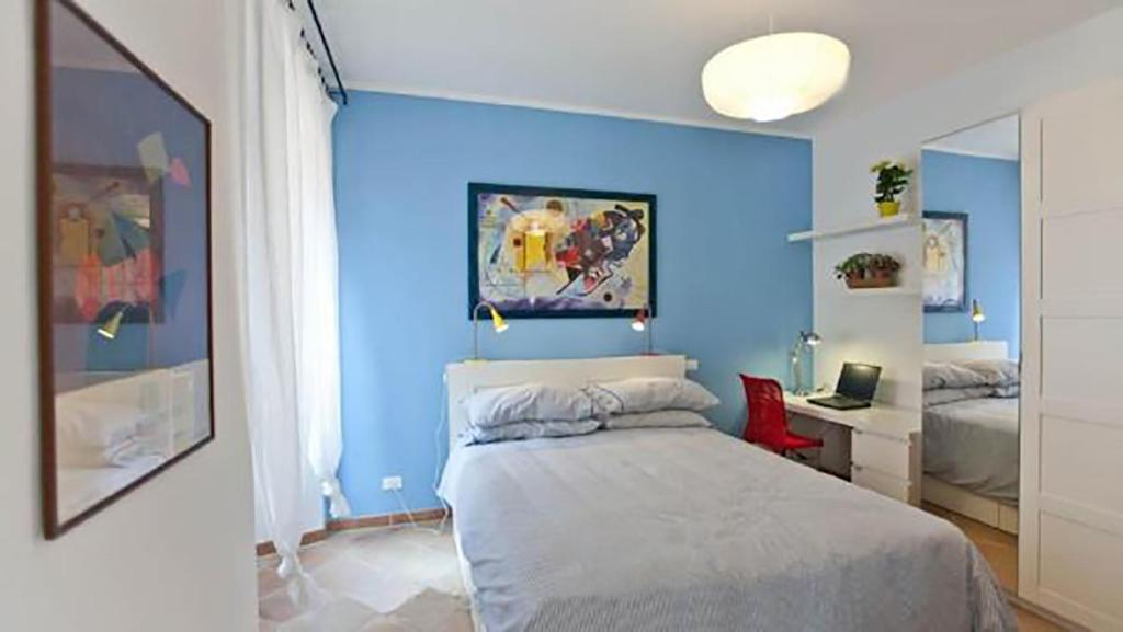 Dormitorio azul con cama y escritorio en Colosseo Luxury Apartment, en Roma