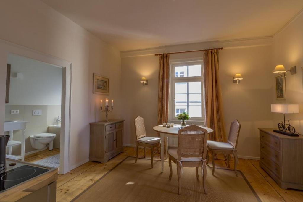 a kitchen with a table and chairs and a bathroom at Apartment Remise in Langenburg
