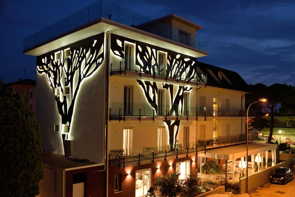 een gebouw met een bord aan de zijkant 's nachts bij Hotel Abc in Cervia