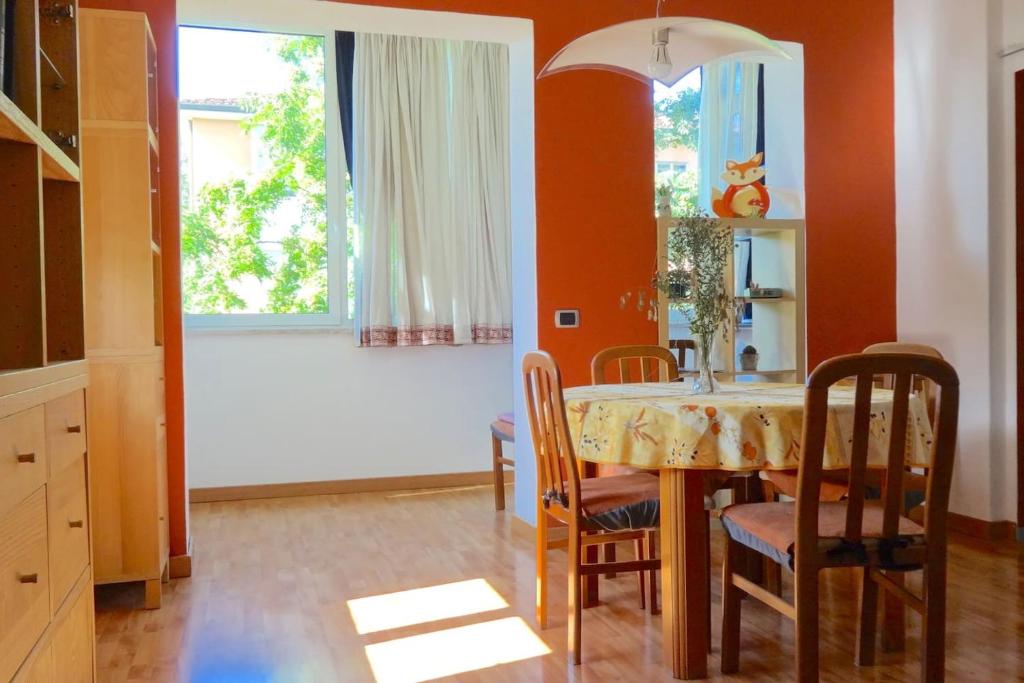 ein Esszimmer mit einem Tisch, Stühlen und einem Fenster in der Unterkunft Livada in Gorizia
