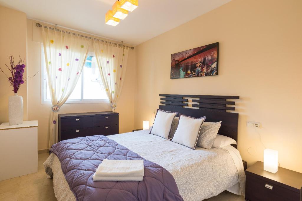 Cama o camas de una habitación en MálagaSuite Torremolinos Beach Apartment