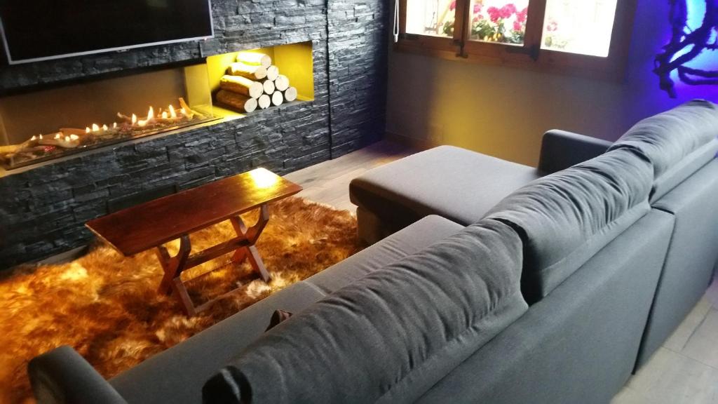 sala de estar con sofá y chimenea en Piso Diseño rústico 4 plazas con Vistas, en Borredá