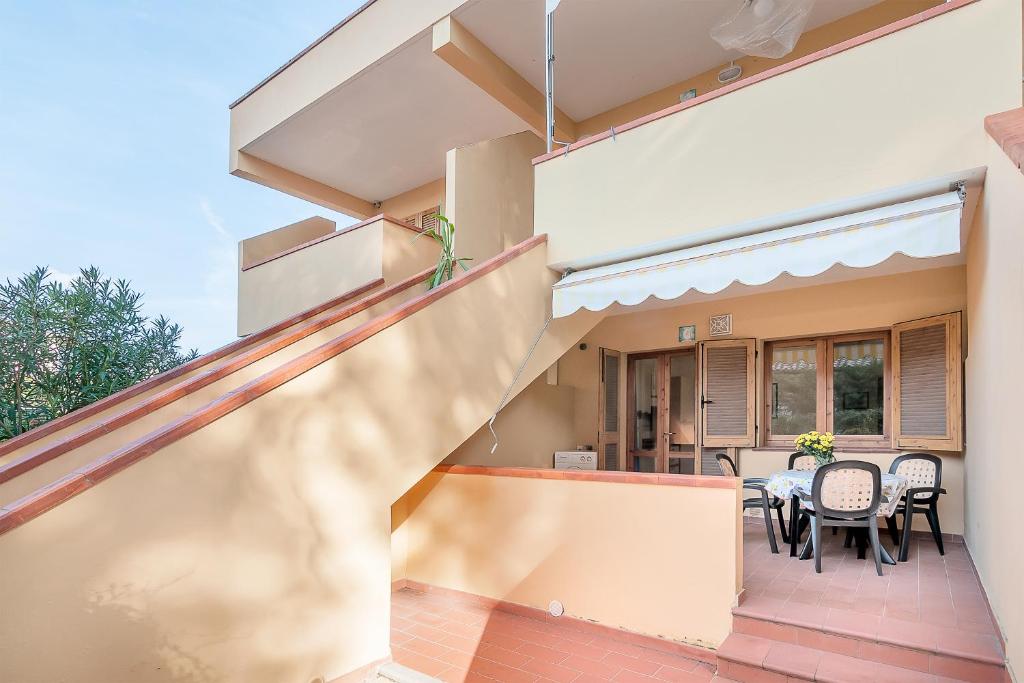 a house with a balcony with a table and chairs at Cassiopea in Marina di Campo