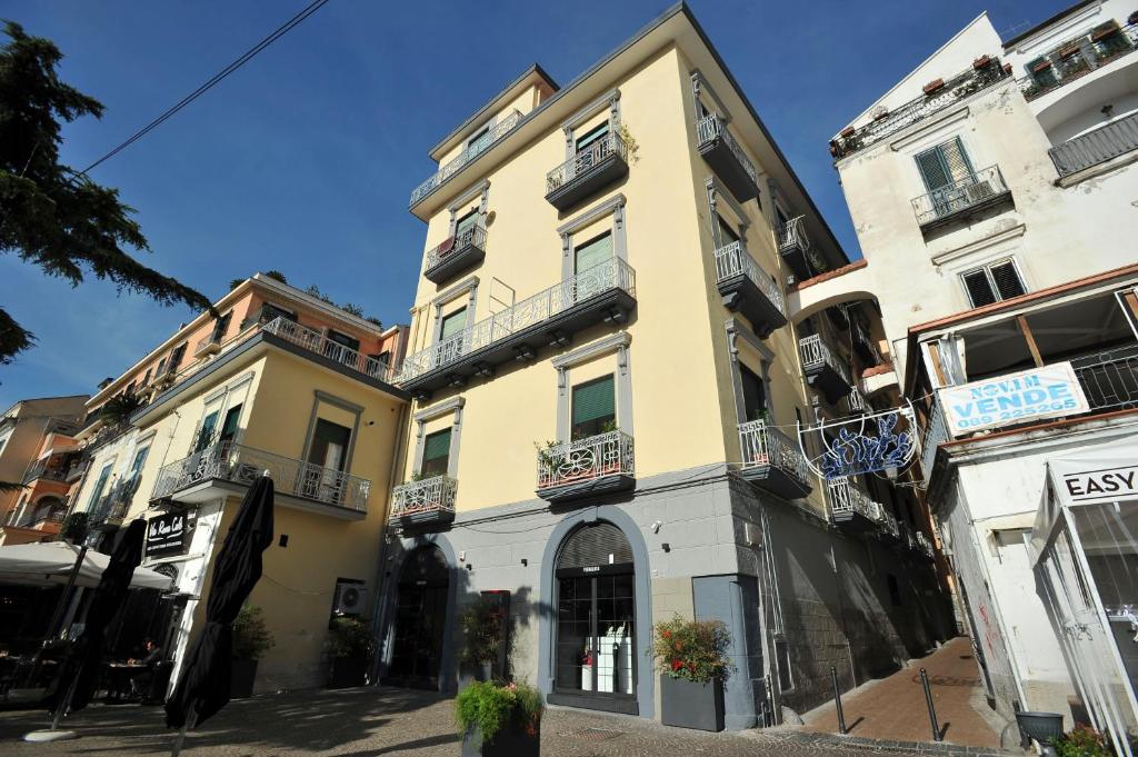 un grand bâtiment jaune avec balcon dans une rue dans l'établissement Casa Vacanza "Al Vicolo delle Colonne", à Salerne