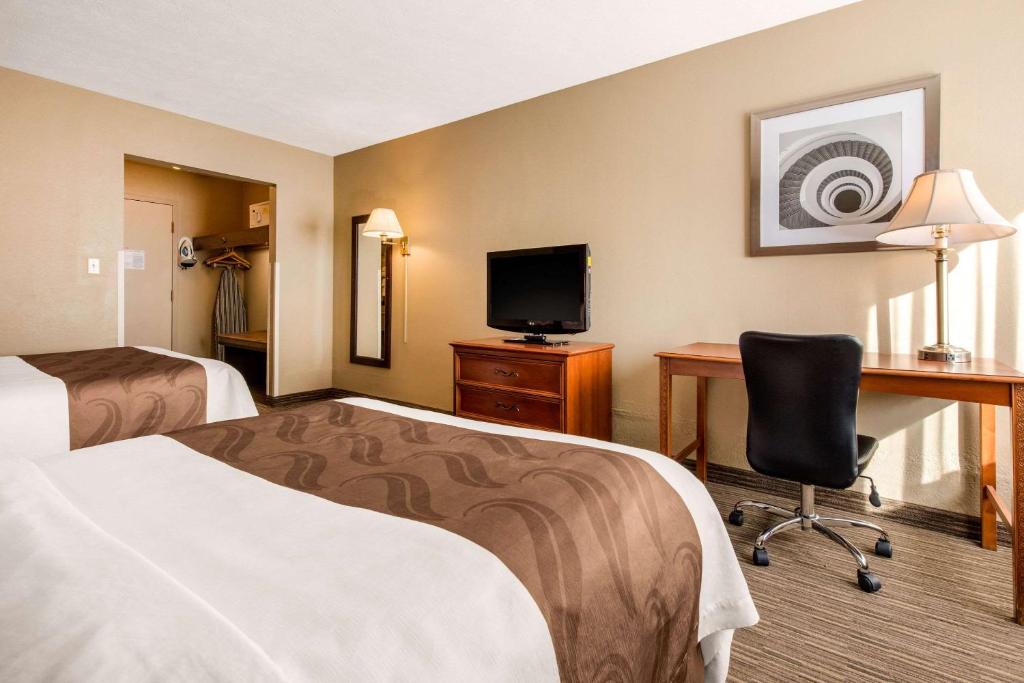 um quarto de hotel com duas camas, uma secretária e um computador em Quality Inn & Suites New Castle em New Castle