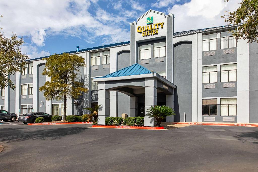 a office building with a sign on the front of it at Quality Suites in Austin