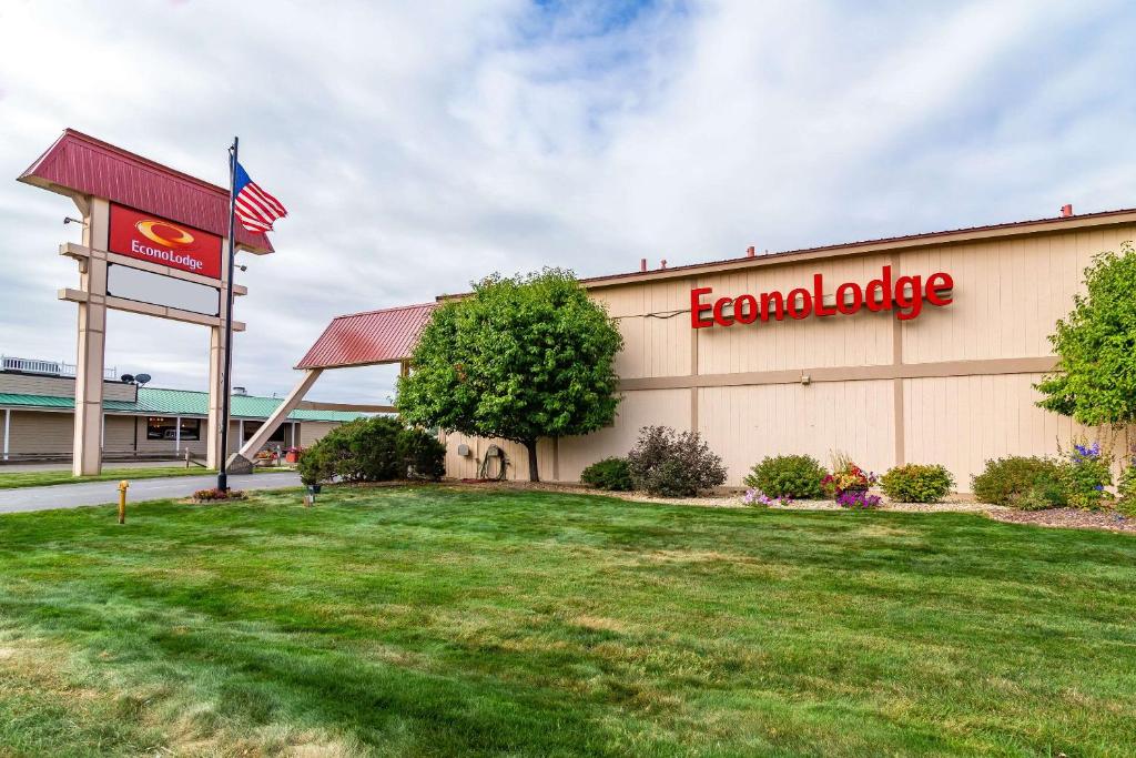 a front view of a dealership with an american flag at Econo Lodge in Miles City