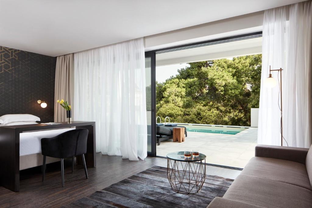a bedroom with a bed and a desk and a sliding glass door at Azur Hotel in Athens