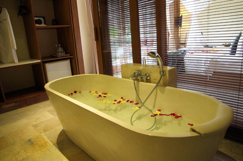 a bathroom with a tub with flowers on it at Sapodilla Ubud in Ubud