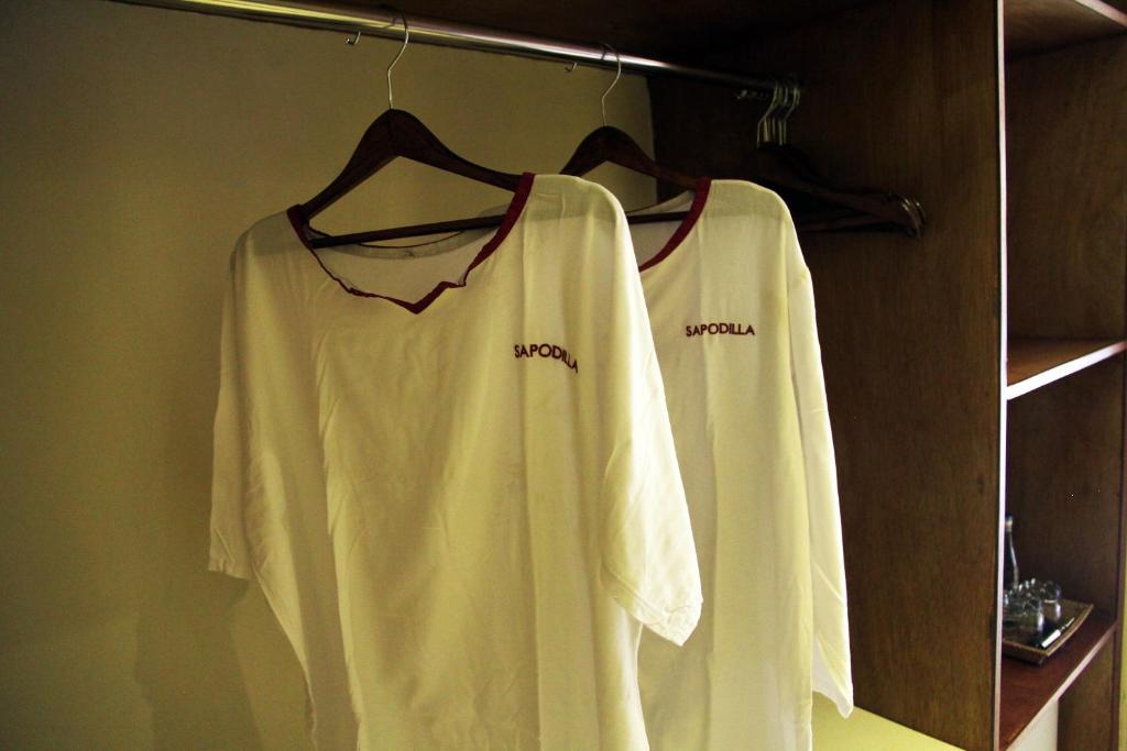 two white shirts are hanging on a rack at Sapodilla Ubud in Ubud
