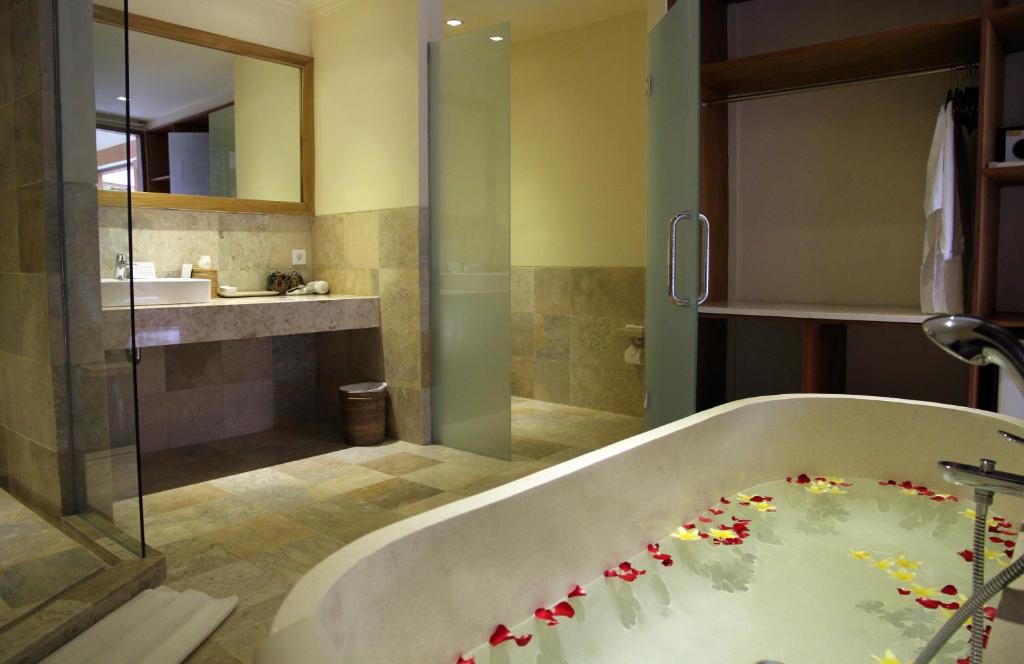 a bathroom with a bath tub with flowers on it at Sapodilla Ubud in Ubud