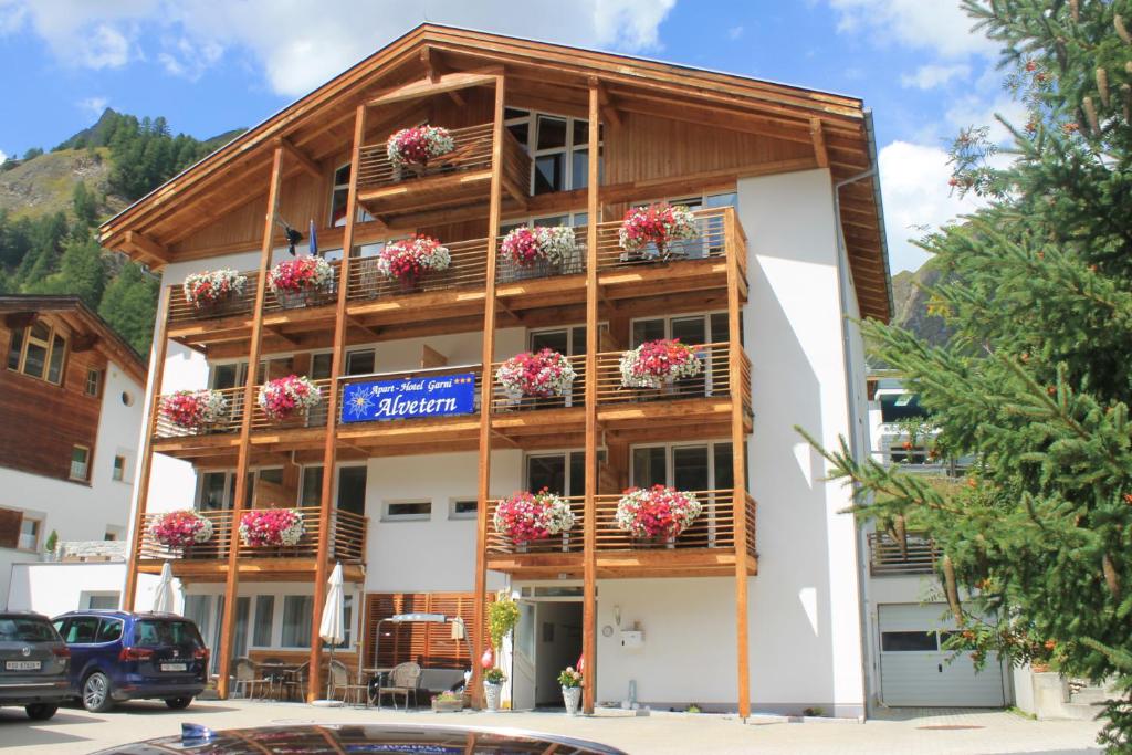 ein Gebäude mit Blumenkästen auf den Balkonen in der Unterkunft Apart Hotel Garni Alvetern in Samnaun