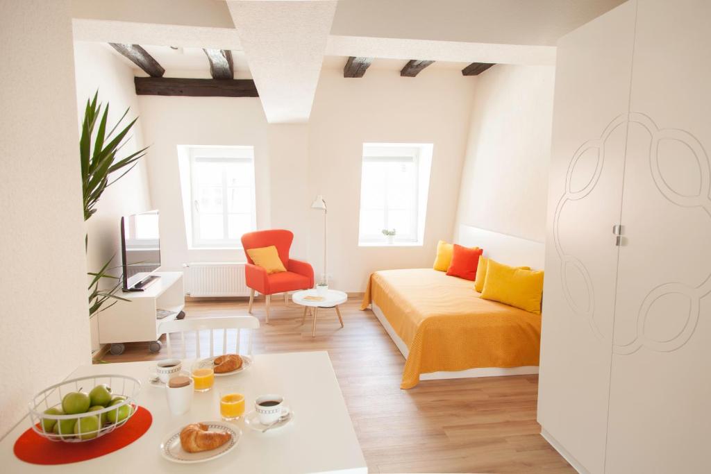 ein Zimmer mit einem Bett und einem Tisch mit Essen darauf in der Unterkunft Boardinghouse s' Johanner in Saarbrücken