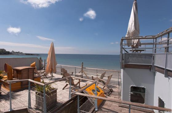 eine Terrasse mit Stühlen und einem Tisch am Strand in der Unterkunft Hôtel Kermor in Concarneau
