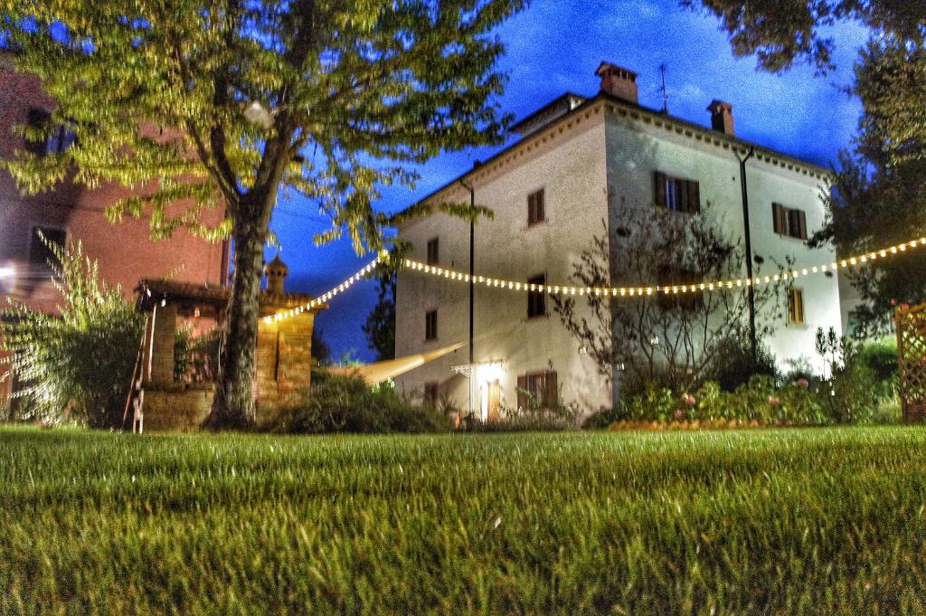 a building with christmas lights in front of a yard at Agriturismo Casa Agricola Rossi Appartamenti in Casentino in Soci