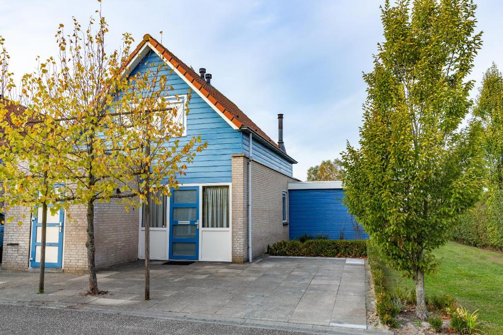 a blue house with a blue garage at Antibes 246 - Kustpark Village Scaldia in Hoofdplaat