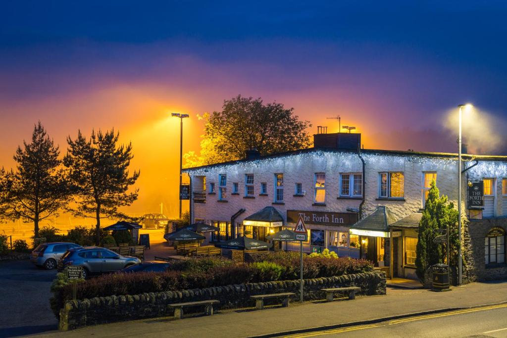 a building in front of a building with a sunset at The Forth Inn in Aberfoyle