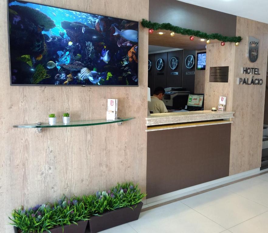um restaurante com um aquário na parede em Hotel Palacio em Paranaguá