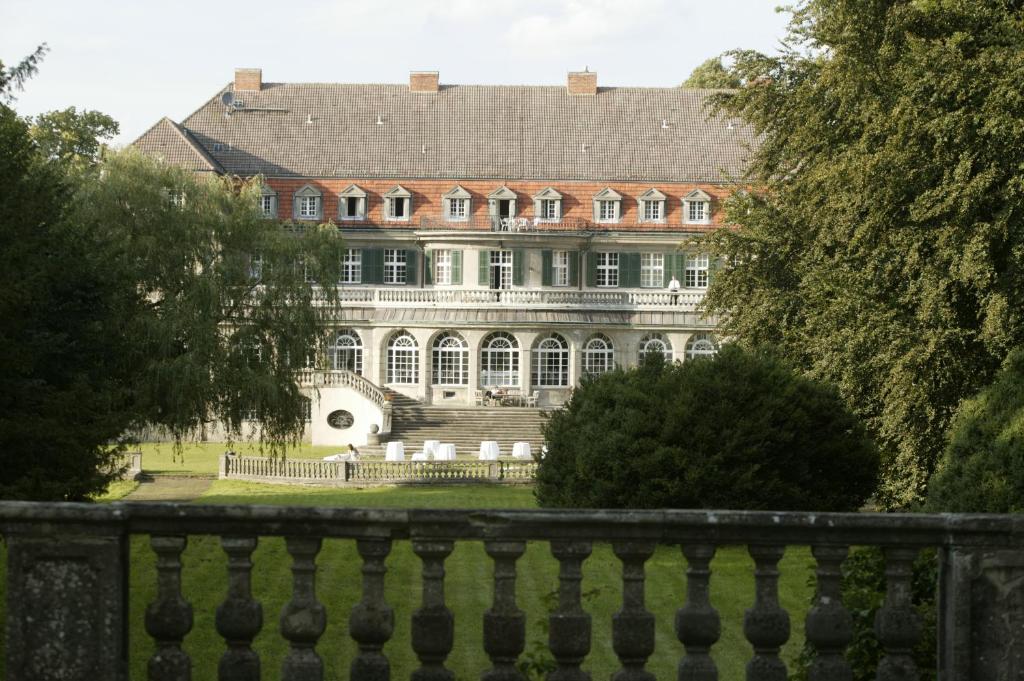 ein großes Haus mit einem Zaun davor in der Unterkunft Jagdschloss-Bellin in Bellin