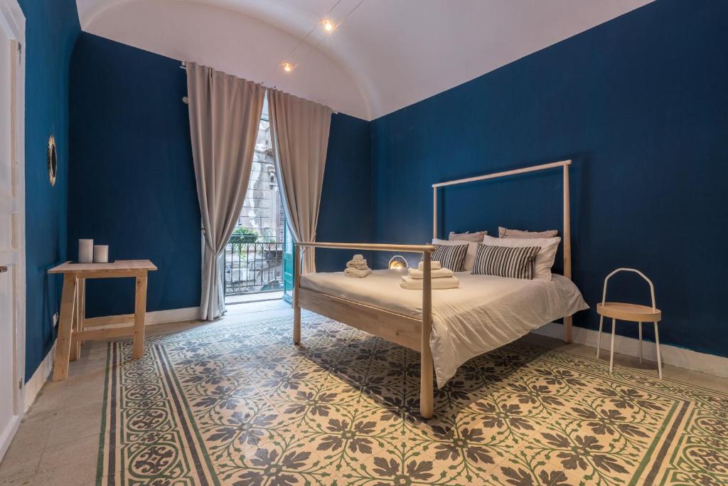 una camera da letto con pareti blu e un letto di Qasr Home Beautiful apartment in Palermo a Palermo