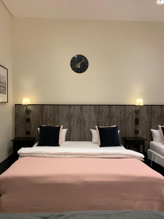 ein Schlafzimmer mit einem großen Bett mit einer Uhr an der Wand in der Unterkunft Hamburg Apart in Hamburg