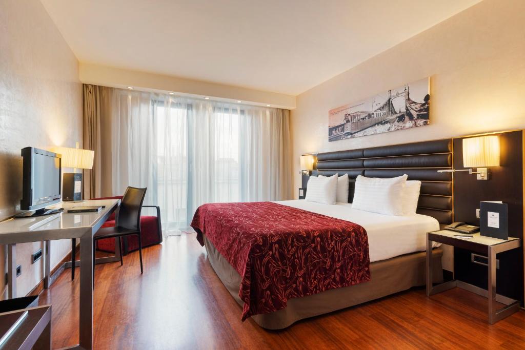 a hotel room with a bed and a desk at Exe Budapest Center in Budapest