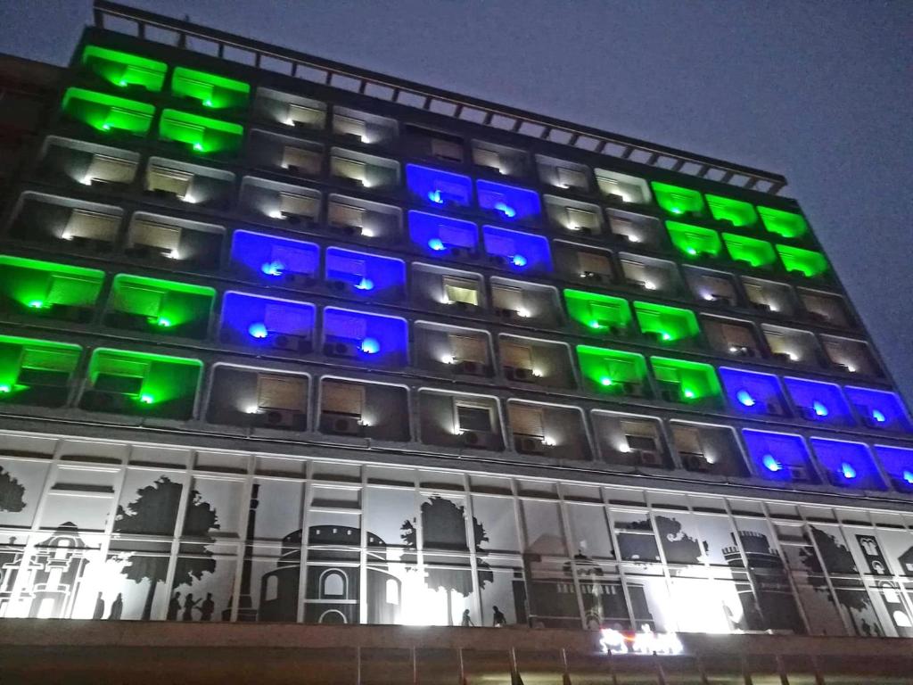 un edificio con luces verdes y azules. en Capsis Hotel Thessaloniki, en Tesalónica