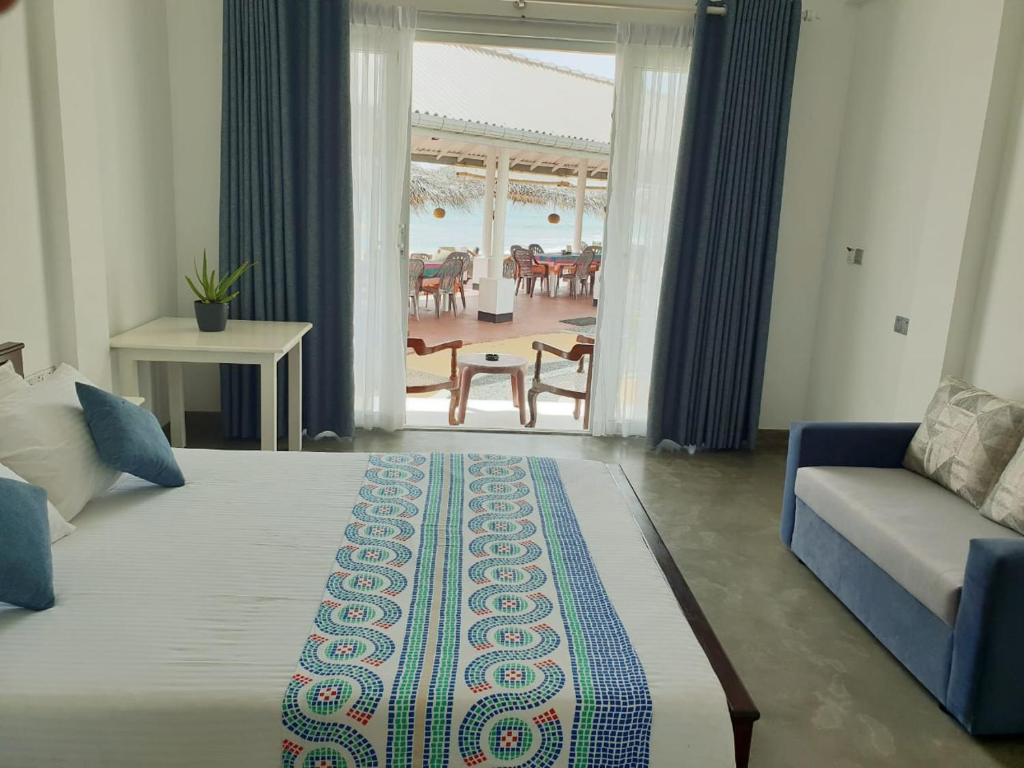 una camera con letto, divano e tavolo di Hotel Blue Note a Hikkaduwa