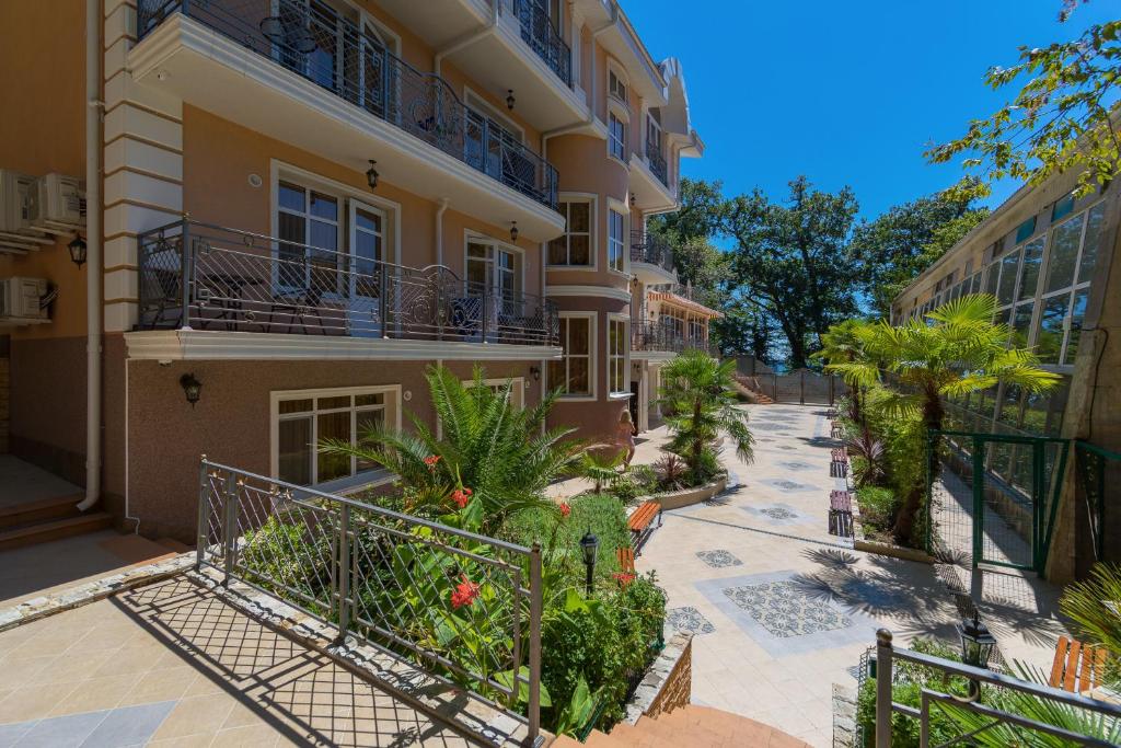 an apartment building with a balcony and plants at Villa Polianna in Sochi